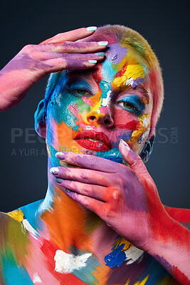 Buy stock photo Studio shot of a young woman posing with multi-coloured paint on her face