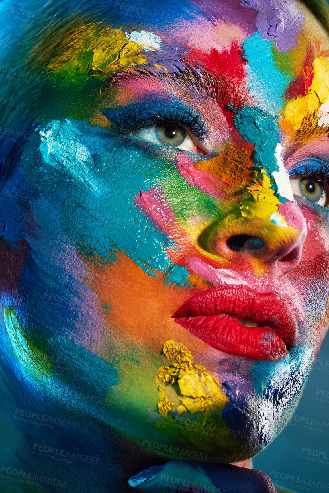 Buy stock photo Studio shot of a young woman posing with multi-coloured paint on her face