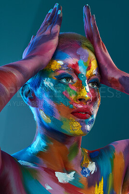 Buy stock photo Studio shot of a young woman posing with multi-coloured paint on her face