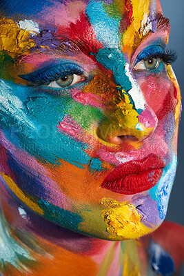 Buy stock photo Studio shot of a young woman posing with multi-coloured paint on her face