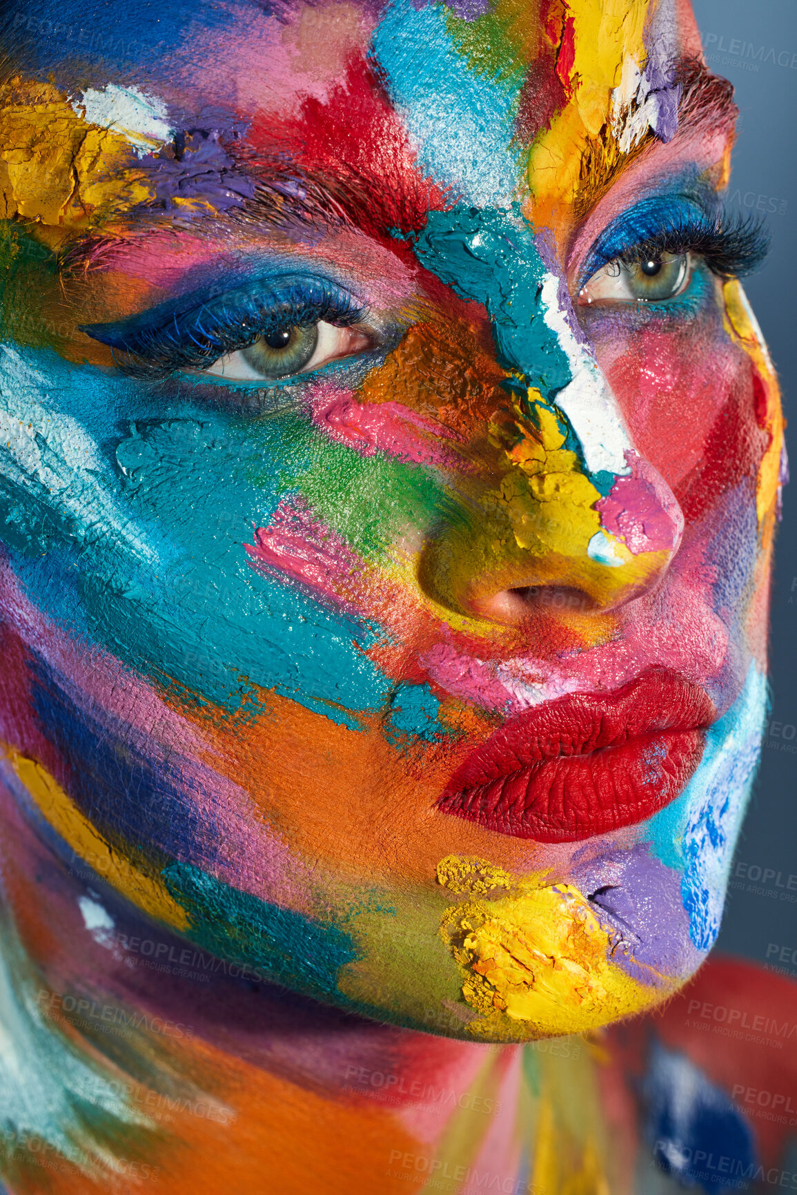 Buy stock photo Studio shot of a young woman posing with multi-coloured paint on her face