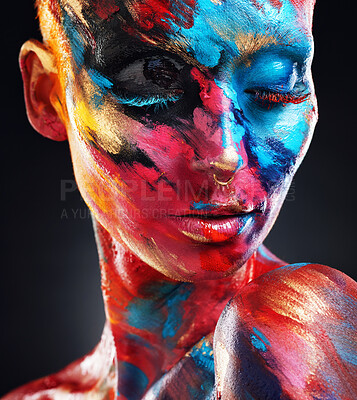 Buy stock photo Shot of an attractive young woman posing alone in the studio with paint on her face