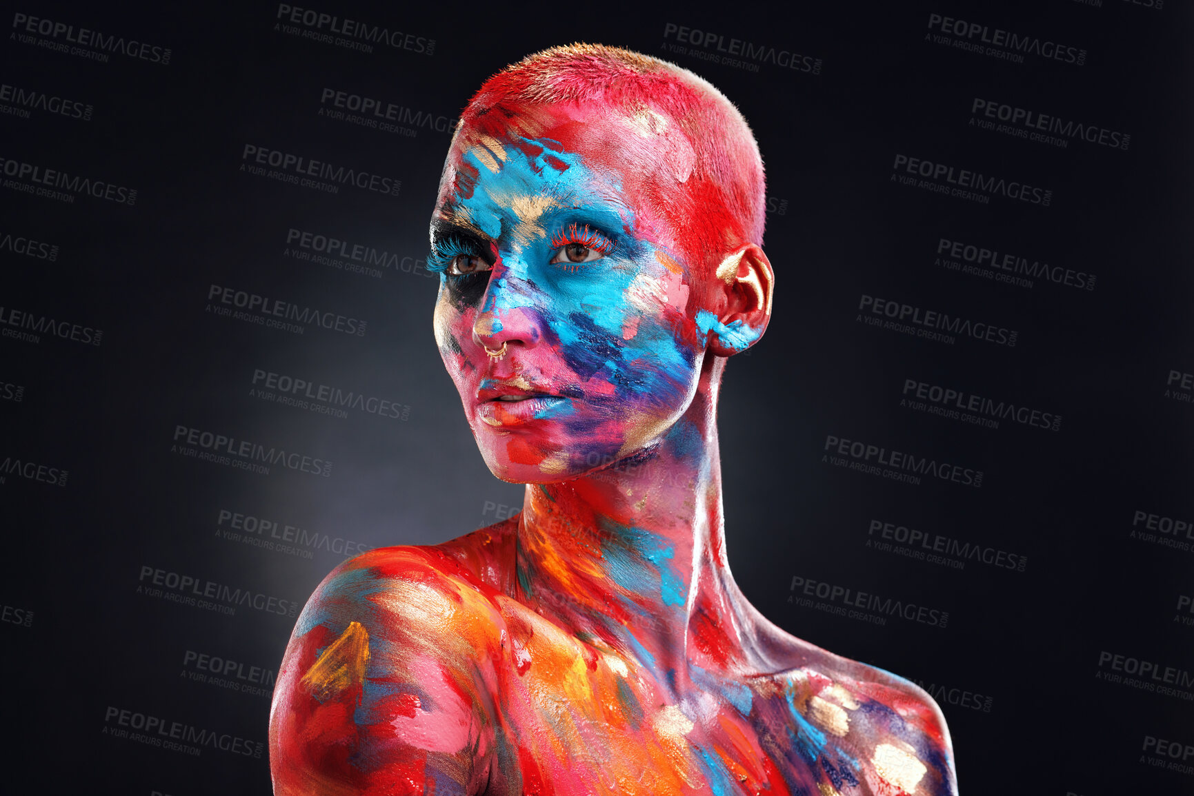 Buy stock photo Shot of an attractive young woman posing alone in the studio with paint on her face and body