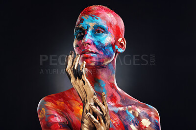 Buy stock photo Shot of an attractive young woman posing alone in the studio with paint on her face and body