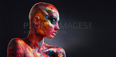 Buy stock photo Shot of an attractive young woman posing alone in the studio with paint on her face and body