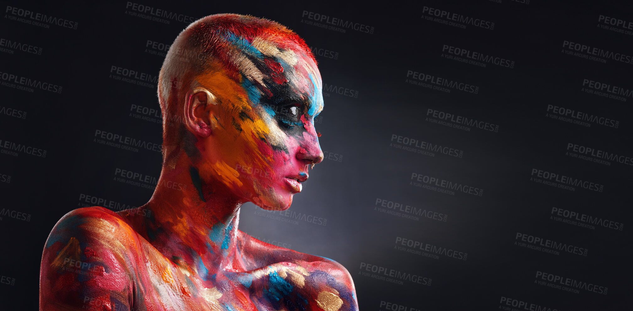 Buy stock photo Shot of an attractive young woman posing alone in the studio with paint on her face and body