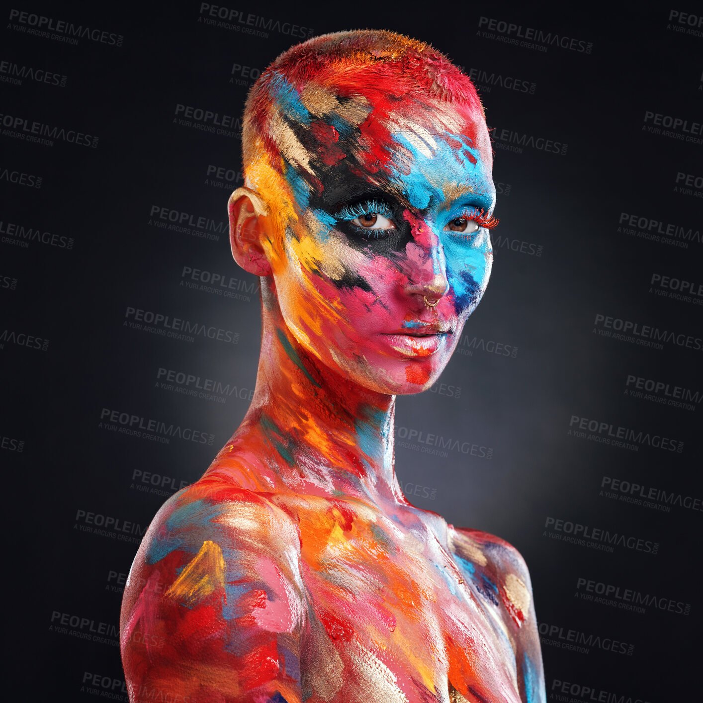 Buy stock photo Shot of an attractive young woman posing alone in the studio with paint on her face and body