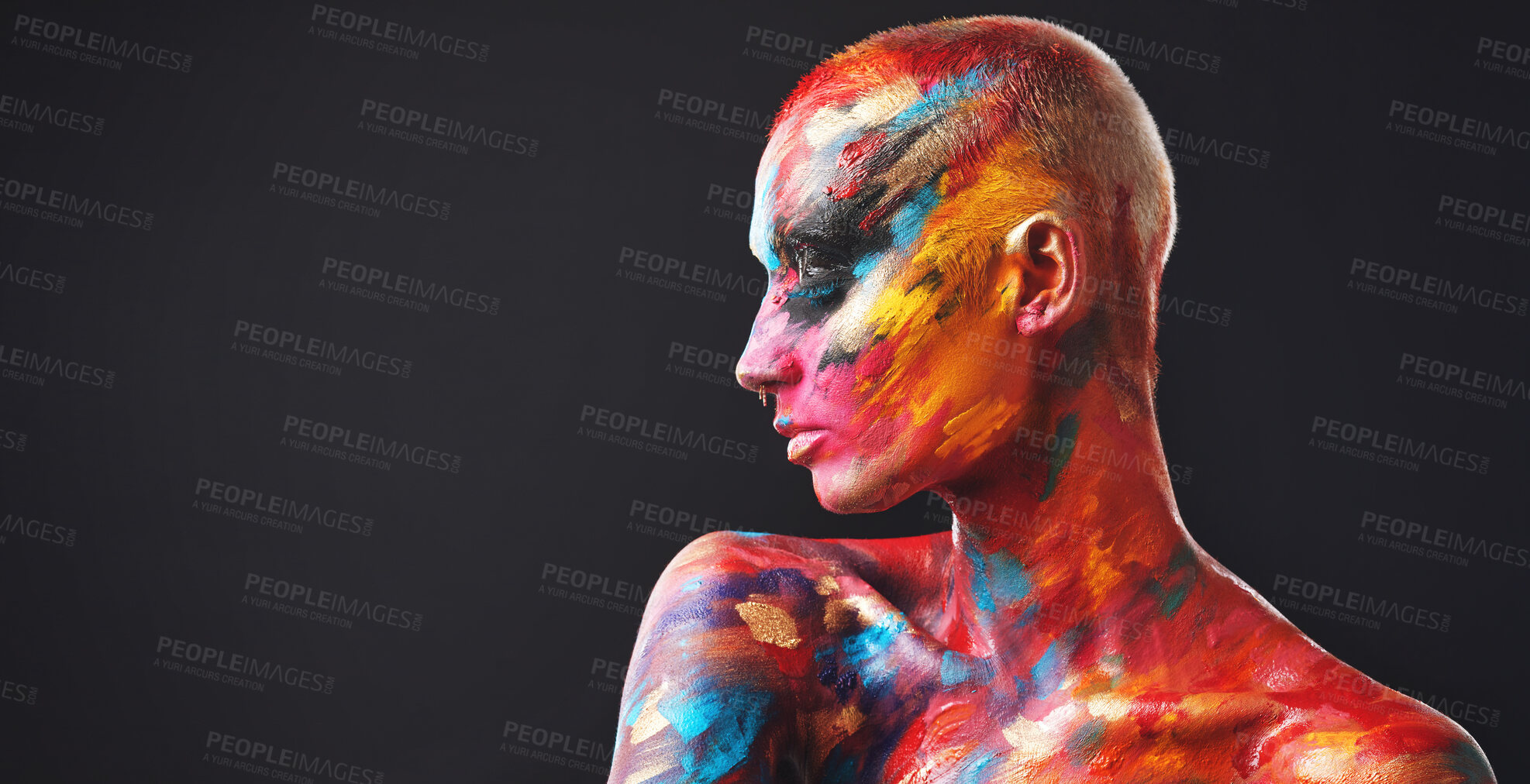 Buy stock photo Shot of an attractive young woman posing alone in the studio with paint on her face and body