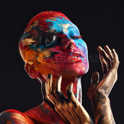 Buy stock photo Shot of an attractive young woman posing alone in the studio with paint on her face