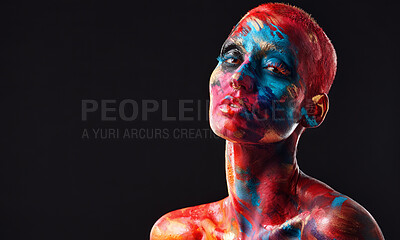 Buy stock photo Shot of an attractive young woman posing alone in the studio with paint on her face and body