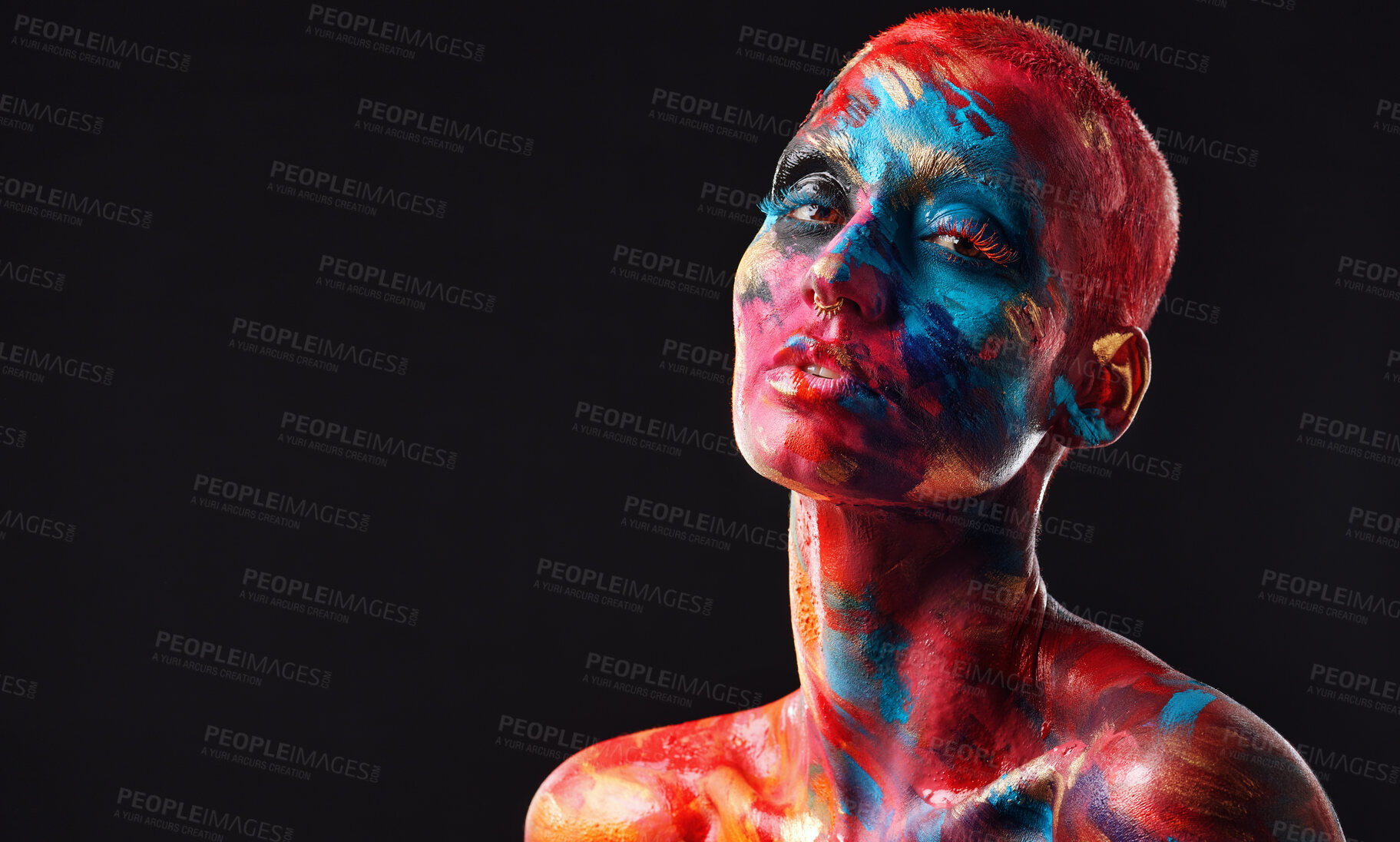 Buy stock photo Shot of an attractive young woman posing alone in the studio with paint on her face and body