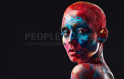 Buy stock photo Shot of an attractive young woman posing alone in the studio with paint on her face