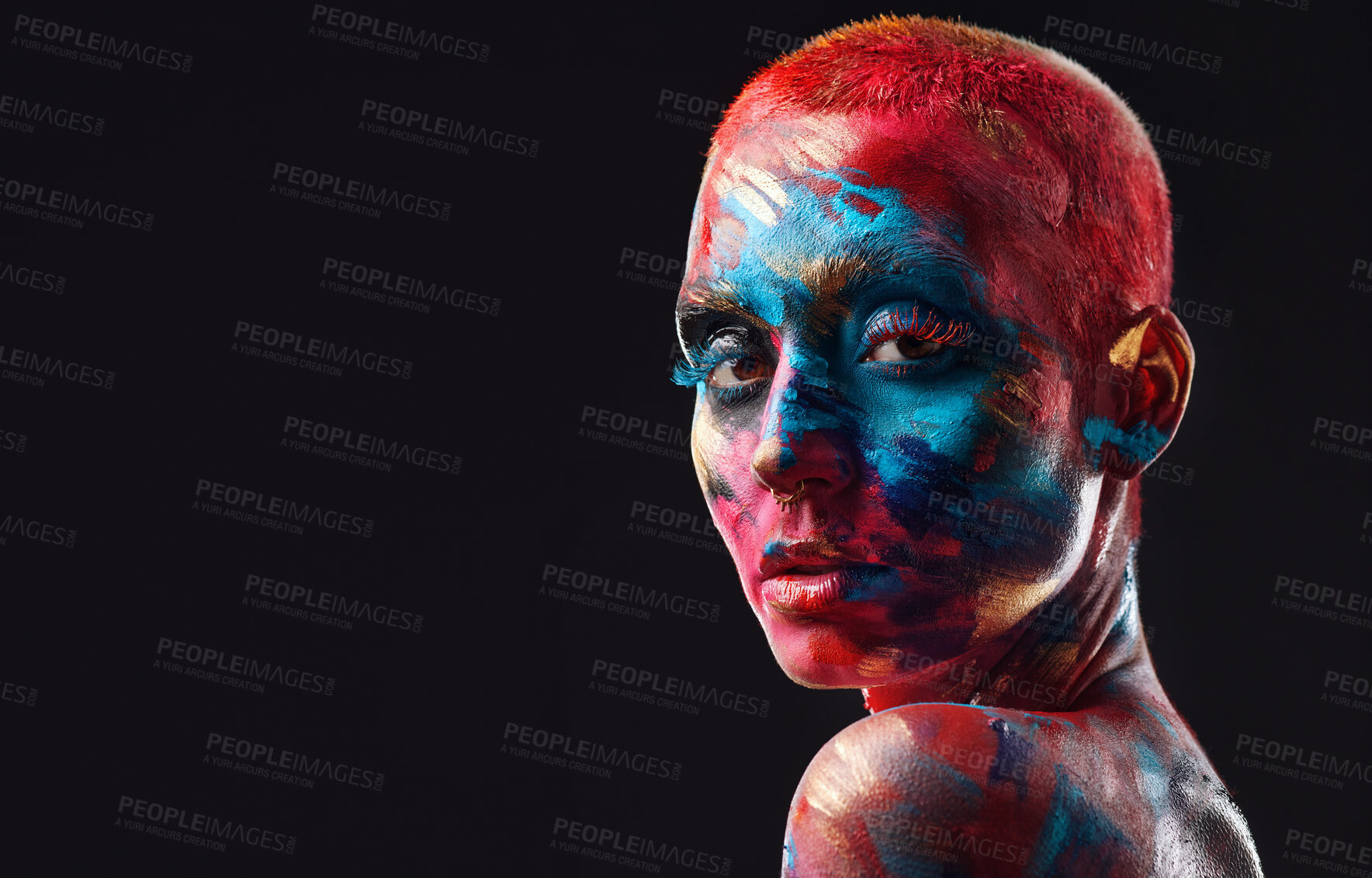 Buy stock photo Shot of an attractive young woman posing alone in the studio with paint on her face