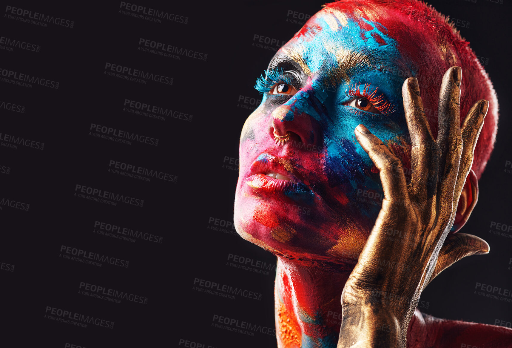 Buy stock photo Shot of an attractive young woman posing alone in the studio with paint on her face