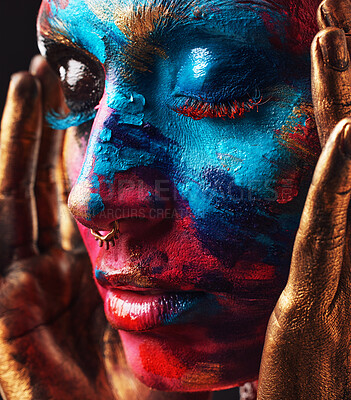 Buy stock photo Shot of an attractive young woman posing alone in the studio with paint on her face