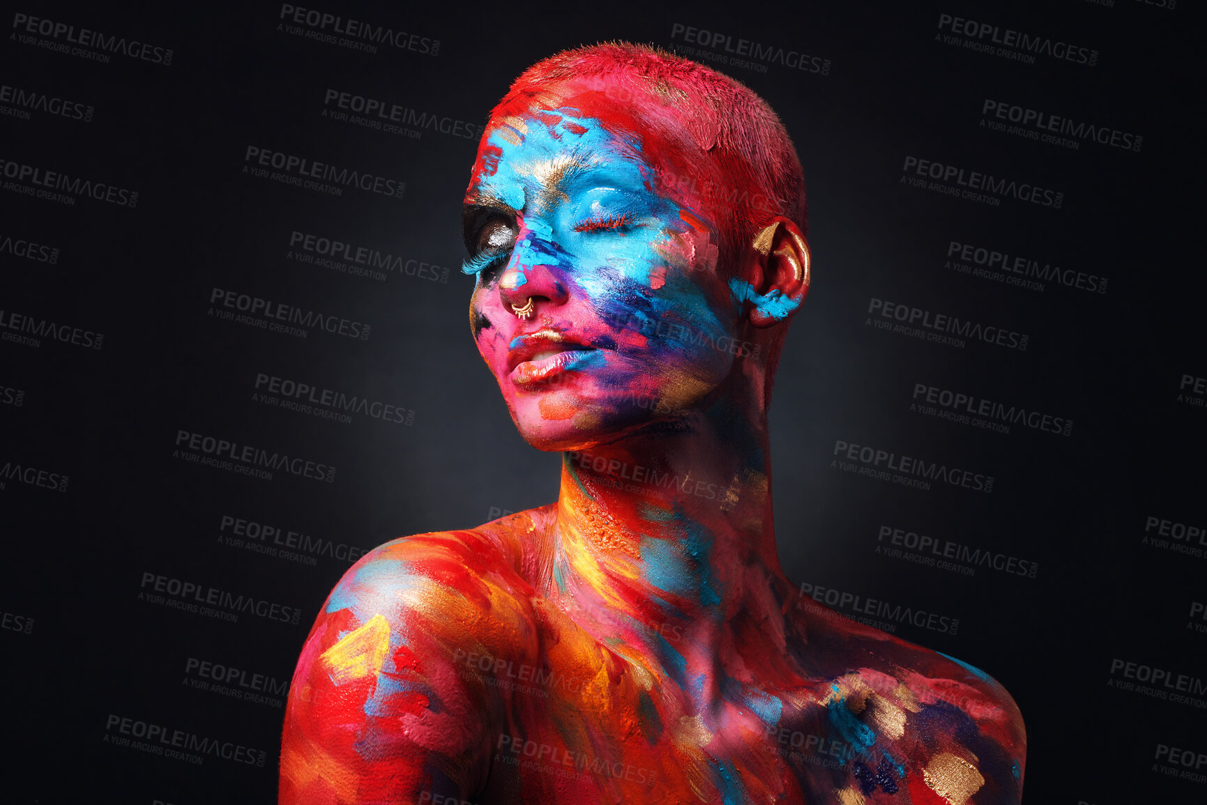 Buy stock photo Shot of an attractive young woman posing alone in the studio with paint on her face and body