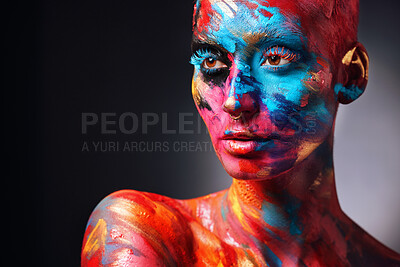 Buy stock photo Shot of an attractive young woman posing alone in the studio with paint on her face and body