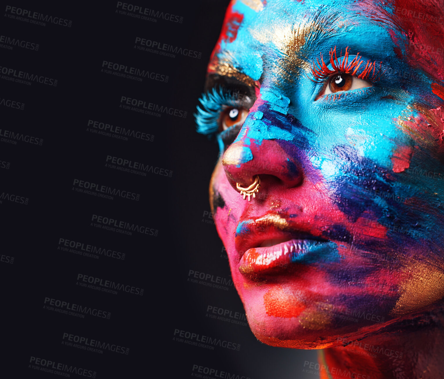 Buy stock photo Shot of an attractive young woman posing alone in the studio with paint on her face