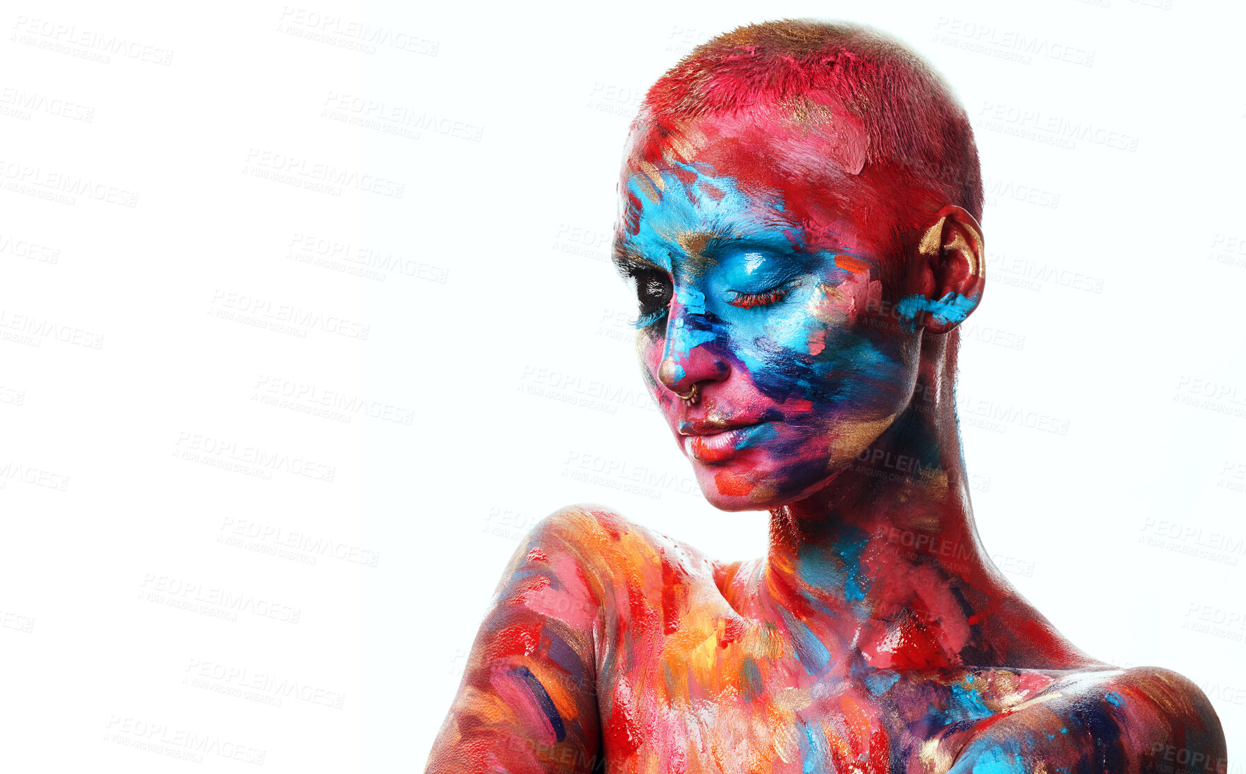 Buy stock photo Shot of an attractive young woman posing alone in the studio with paint on her face and body