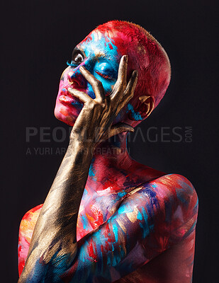 Buy stock photo Shot of an attractive young woman posing alone in the studio with paint on her face and body