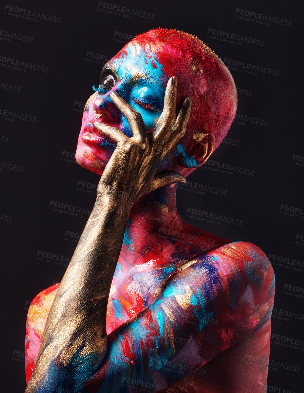 Buy stock photo Shot of an attractive young woman posing alone in the studio with paint on her face and body