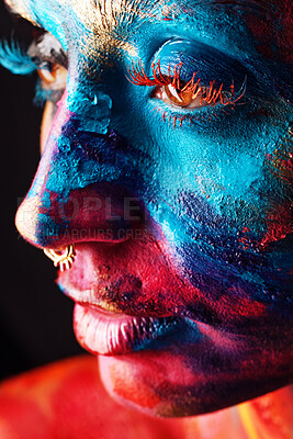 Buy stock photo Shot of an attractive young woman posing alone in the studio with paint on her face