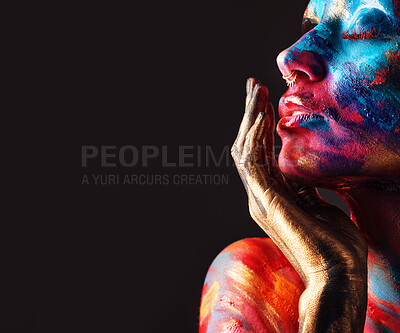 Buy stock photo Cropped shot of an attractive young woman posing alone in the studio with paint on her face