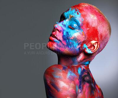 Buy stock photo Shot of an attractive young woman posing alone in the studio with paint on her face and body