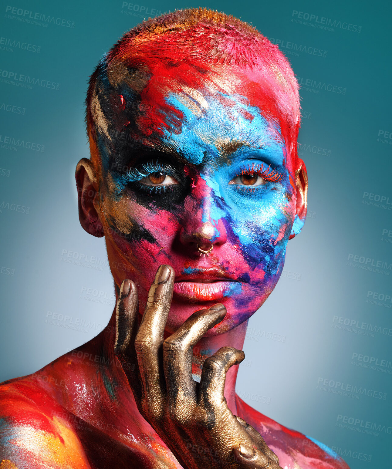 Buy stock photo Shot of an attractive young woman posing alone in the studio with paint on her face