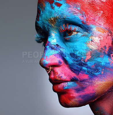 Buy stock photo Shot of an attractive young woman posing alone in the studio with paint on her face