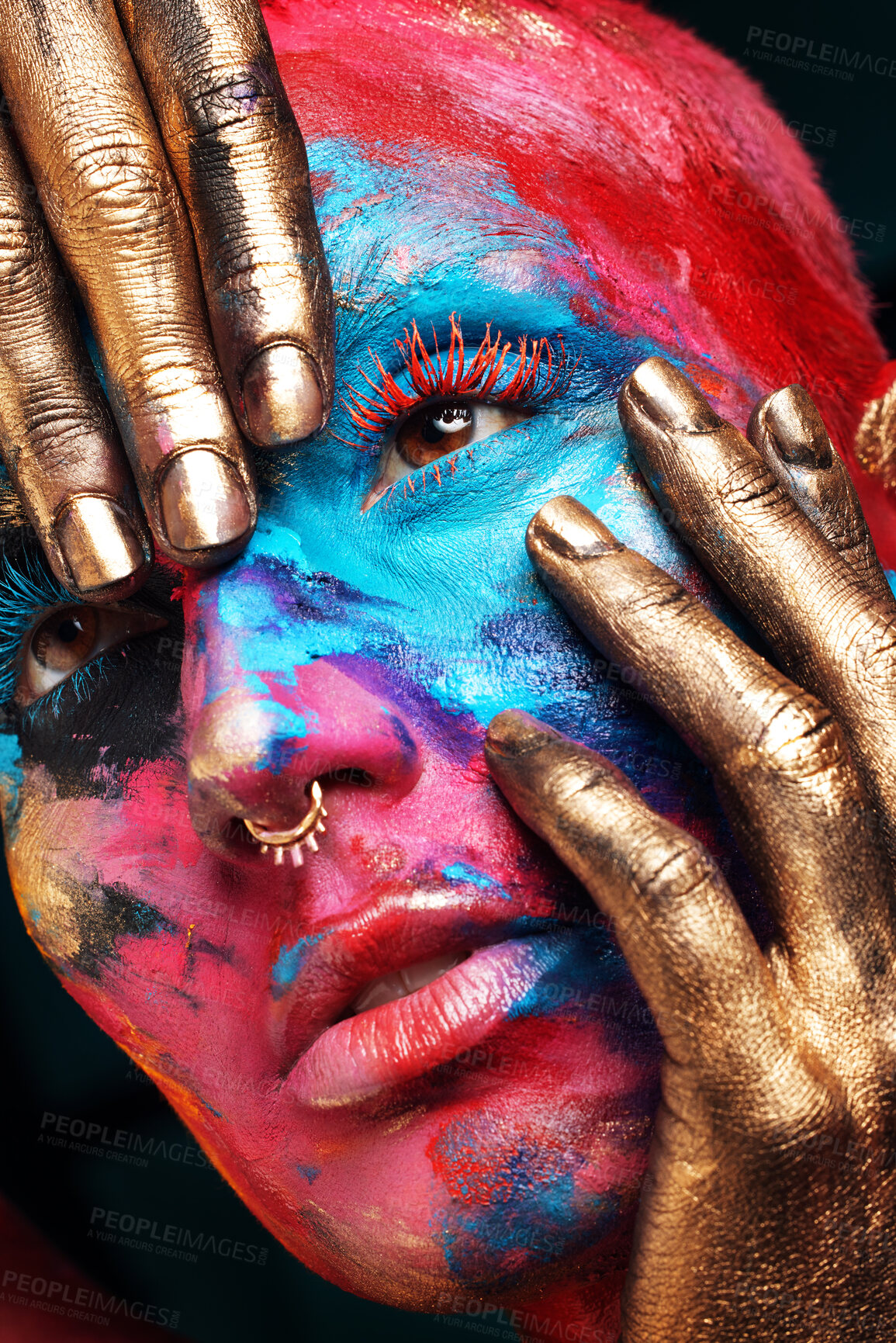 Buy stock photo Shot of an attractive young woman posing alone in the studio with paint on her face