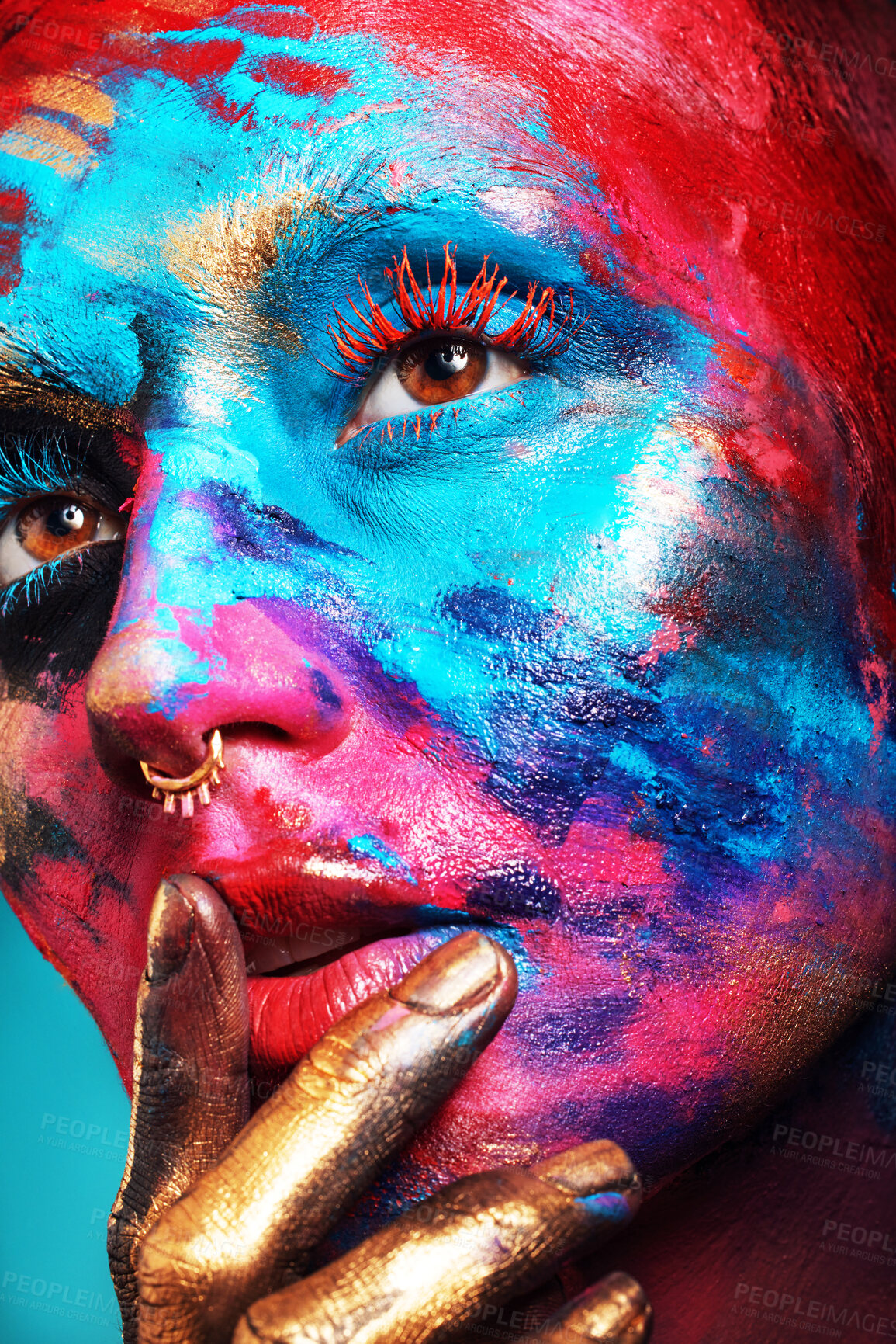 Buy stock photo Shot of an attractive young woman posing alone in the studio with paint on her face