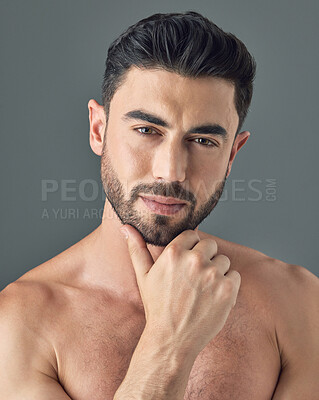 Buy stock photo Shot of a handsome young man posing against a grey background