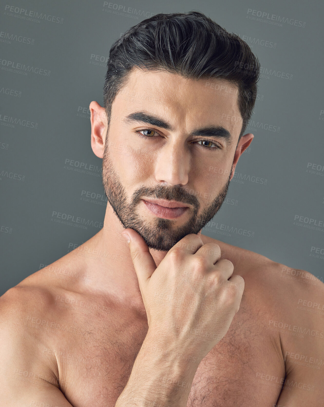 Buy stock photo Shot of a handsome young man posing against a grey background