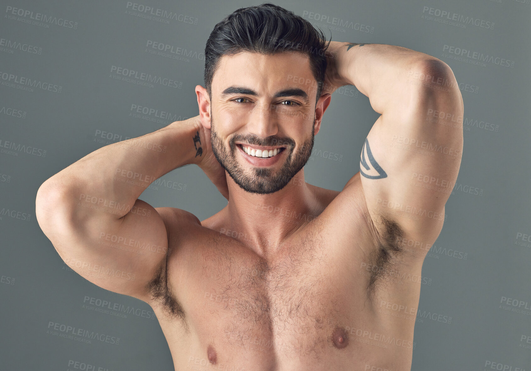 Buy stock photo Shot of a handsome young man posing against a grey background