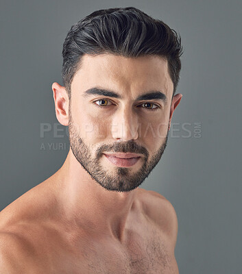 Buy stock photo Shot of a handsome young man posing against a grey background