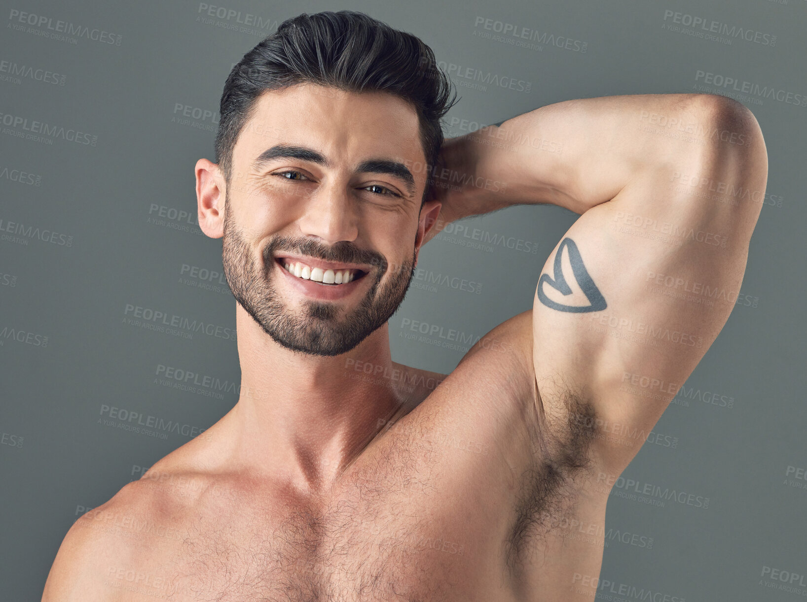 Buy stock photo Shot of a handsome young man posing against a grey background