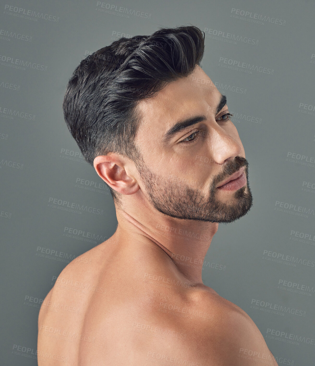 Buy stock photo Shot of a handsome young man posing against a grey background