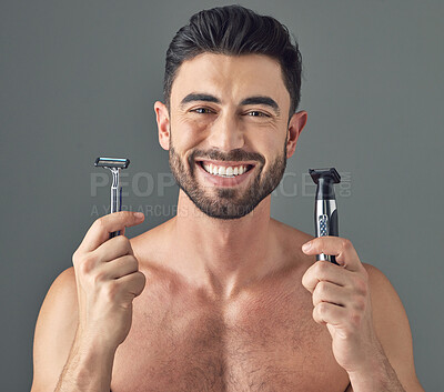 Buy stock photo Studio shot of a man holding up a disposable razor and an electric shaver