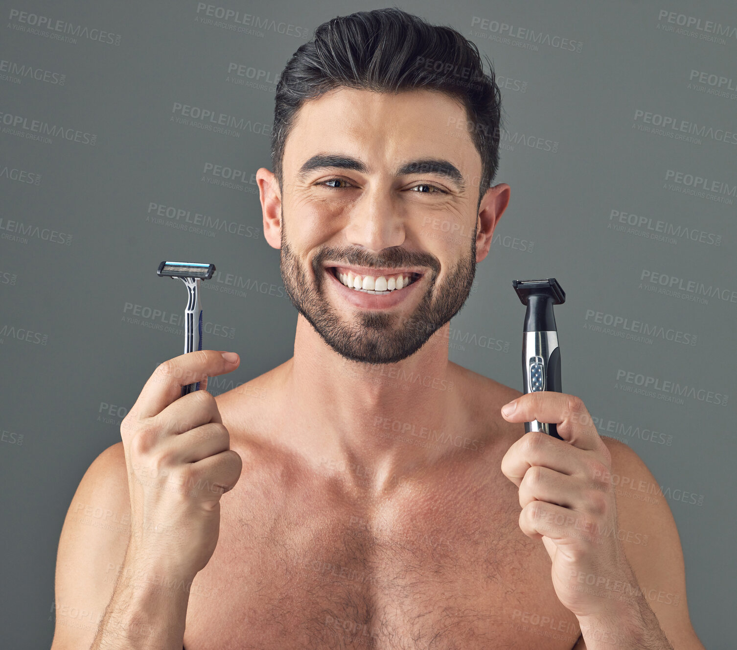 Buy stock photo Studio shot of a man holding up a disposable razor and an electric shaver