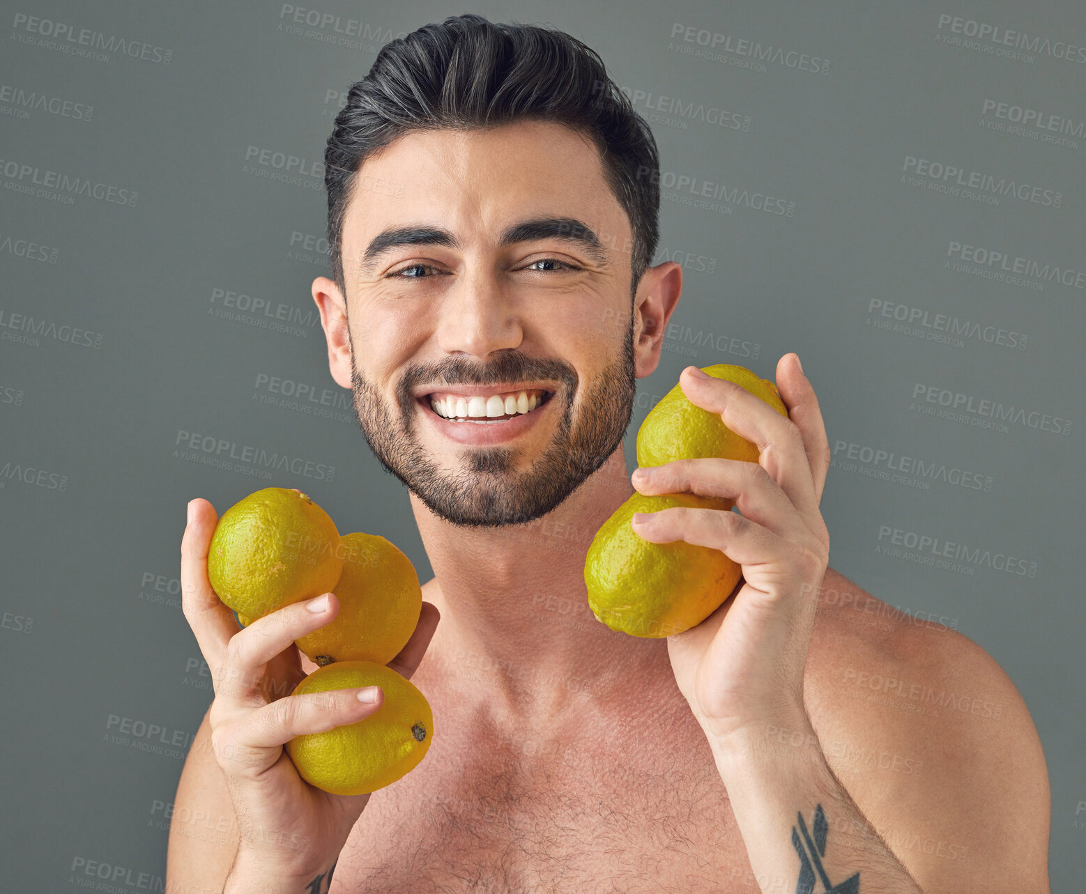 Buy stock photo Studio shot of a handsome young man holding lemons