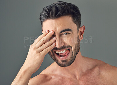 Buy stock photo Shot of a handsome young man posing against a grey background