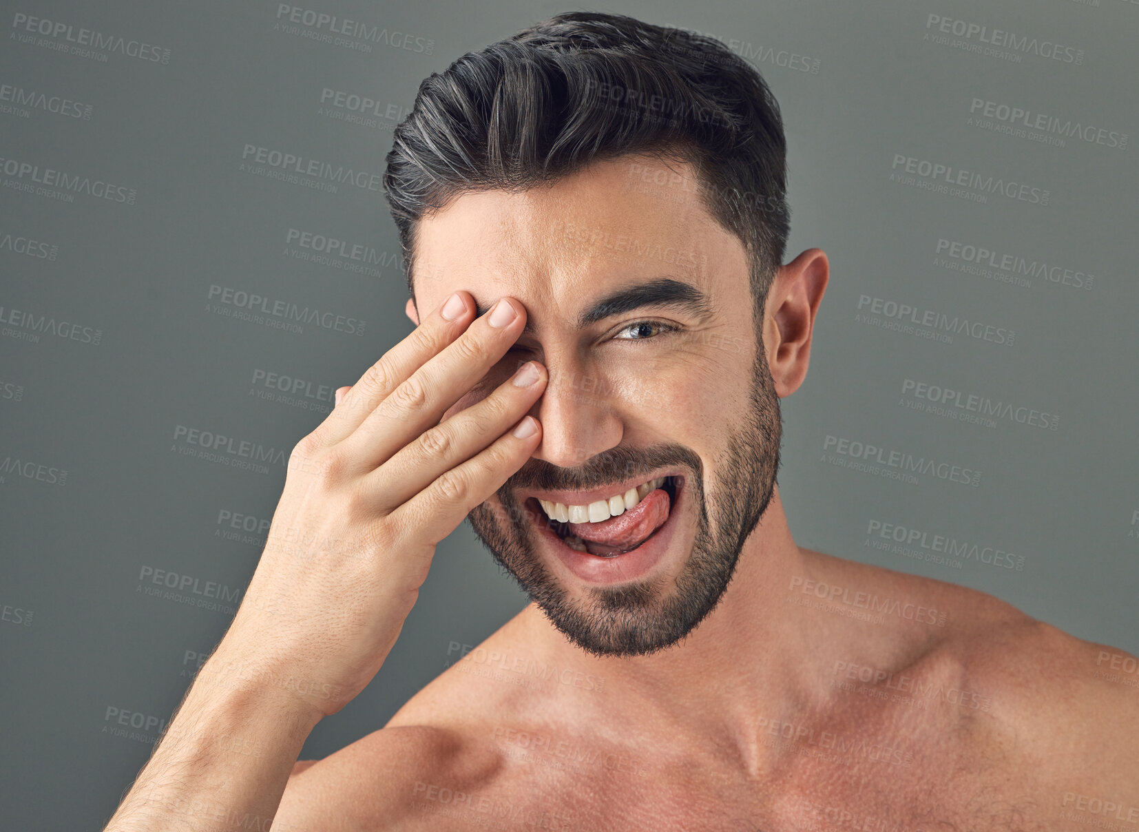 Buy stock photo Shot of a handsome young man posing against a grey background