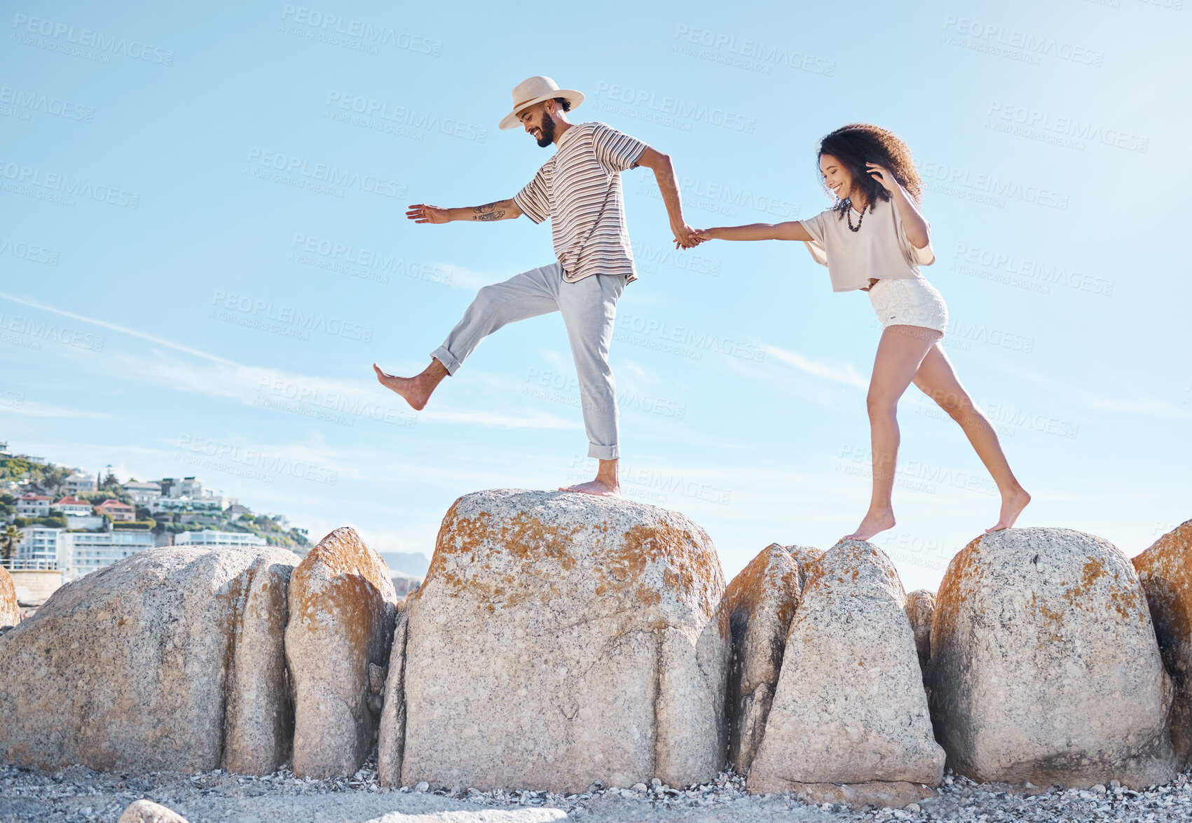 Buy stock photo Beach, rocks and couple with holiday, walking and travel with happiness, bonding together and carefree. Seaside, fun and man with woman, adventure and journey with weekend break, vacation and summer