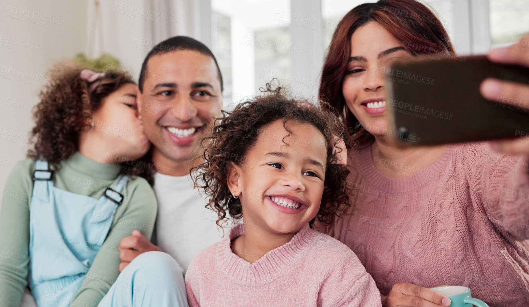 Buy stock photo Shot of a happy family taking selfies together at home