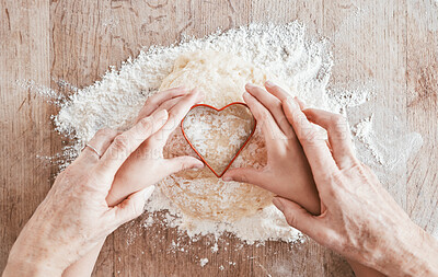 Buy stock photo Hands, baking and heart shape with a girl and grandmother learning how to bake in the kitchen of their home together. Family, children and food with a woman and granddaughter bonder over cooking