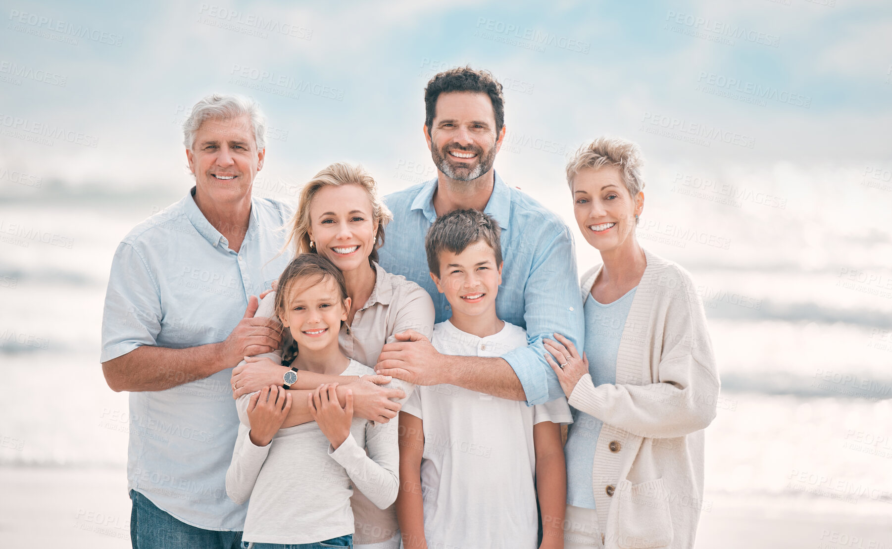 Buy stock photo Hug, generations and portrait with family on beach for holiday, travel or vacation. Happy, smile or summer with senior people, parents and sibling children embracing outdoor for bonding or wellness