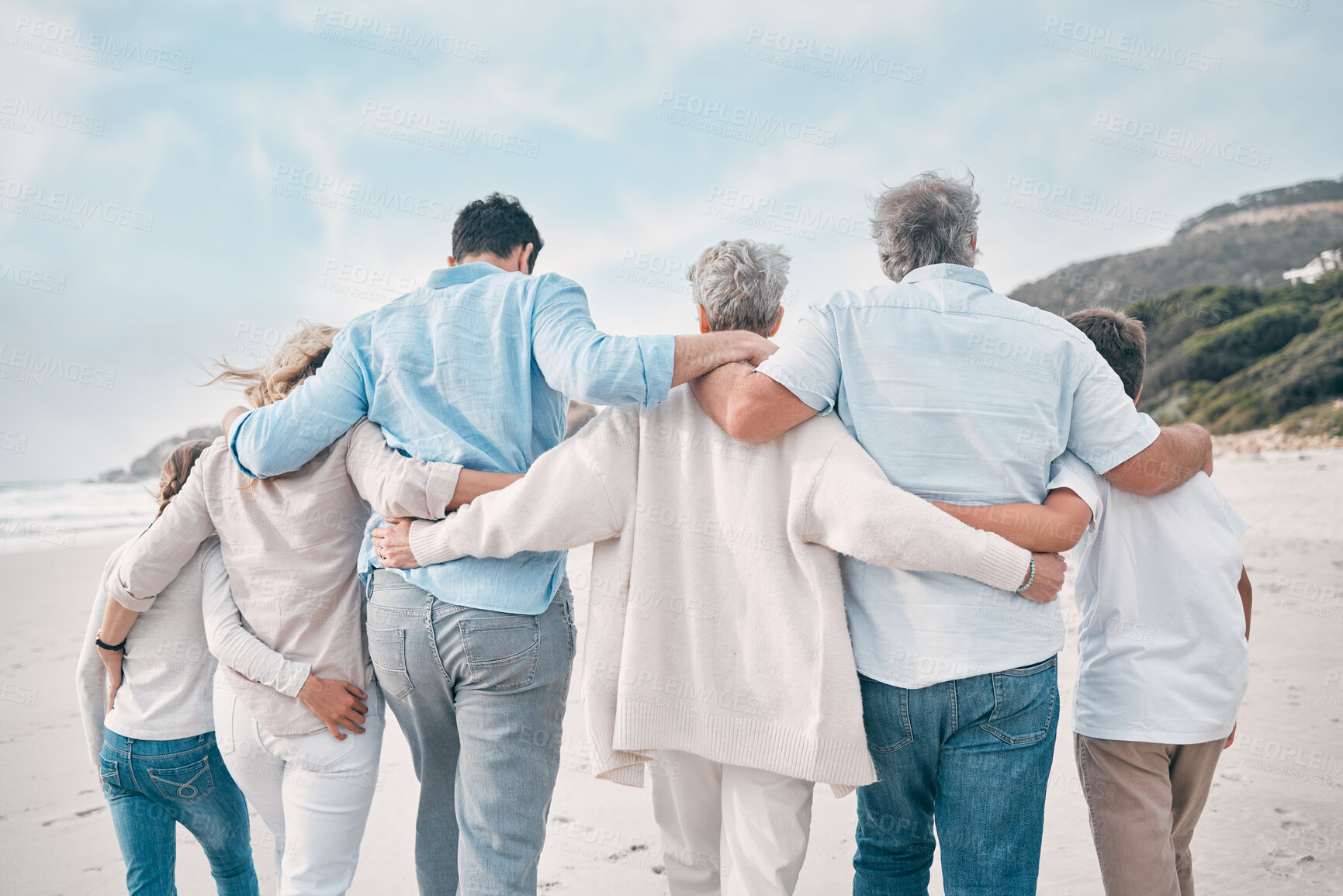 Buy stock photo Hug, love and walking with family on beach together for holiday, travel or vacation in summer. Back, sand or sky with senior people, parents and children at ocean or sea for tropical getaway