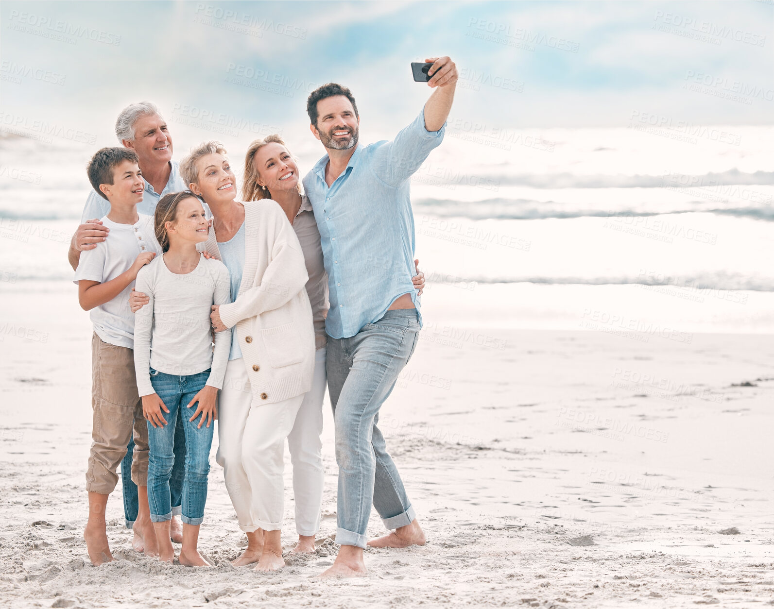 Buy stock photo Hug, love and selfie with family on beach together for holiday, travel or vacation in summer. Sand, sky or space with happy senior people, parents and kids at ocean or sea for memory or photograph