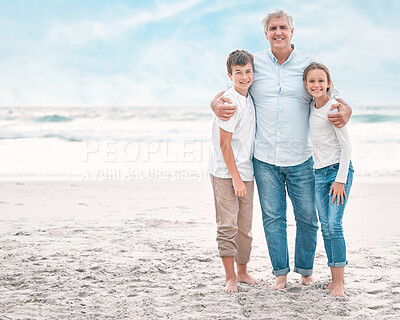 Buy stock photo Shot of a mature man and his grandchildren bonding at the beach